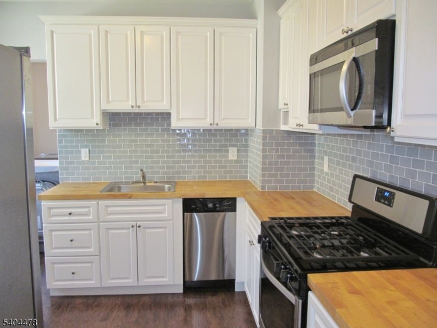 Beautifully Renovated First Floor 3 Bedroom Apartment with Lots of Utilities Included! Featuring: Gorgeous Wood Laminate Floors Throughout, Newer Kitchen with Stainless Steel Appliances, Recessed Lighting, Newer LG Front Loader Stainless Steel Washer and Dryer, Spacious and Stylish Newer Full Bathroom, Newer Energy Efficient Windows Throughout, Large Primary Bedroom, Common Area Foyer, Private Off-Street Parking, Big Back Yard with Picnic Table Set Up and Newer Storage Shed. Rent Includes Heat, Hot / cold Water, and Sewer charge Close to Dunellen Train Station, Major Highways, Shopping and Dining. Must See!  **Credit Check - Good Credit Scores, Proof of Qualifying Income and Legal Form of Picture I.D. Required**