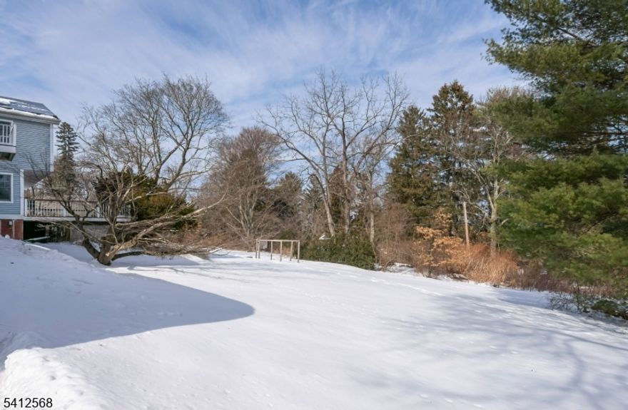 You won't want to miss this exceptional five-bedroom home nestled on nearly one acre of private property.  Completely rebuilt from the foundation up in 2006, this home offers the perfect blend of modern updates and spacious design. Step inside to a wonderful open floor plan featuring a stunning wall of patio doors that lead to a generous Trex deck - ideal for entertaining or relaxing while enjoying the peaceful surroundings.  The kitchen is beautifully appointed with granite countertops, maple cabinetry, stainless steel appliances and a large pantry for added convenience.  The living room offers elegant French doors just off the dining room creating a warm and inviting flow for gatherings.  Upstairs, the spacious primary suite features a private balcony overlooking the backyard with seasonal lake views in the winter, an ensuite bath, walk-in closet and a dedicated dressing room.  Four additional bedrooms provide ample space with walk-in closets in all but one.  The main bath includes a tub/shower combination and dual vanities.  Hardwood floors run throughout both levels adding warmth and timeless appeal to this truly move-in home.  ALL OFFERS DUE BY THURSDAY, 3/5 AT NOON