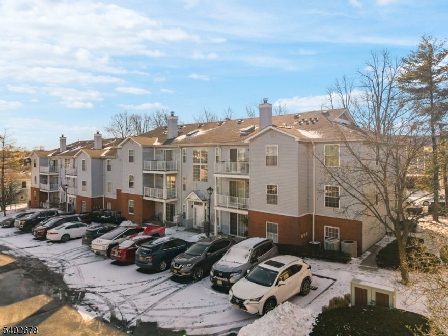 Ideally situated in the sought-after Forest Hills community, this upgraded top-floor 2-bedroom, 1-bath residence offers 998 square feet of stylish, light-filled living. The home features beautiful wood flooring through out the living space,  vaulted ceilings, crown molding, new vinyl flooring in the bedrooms, and an open, airy layout flooded with natural light. The spacious living room is anchored by a charming wood-burning stone fireplace, creating a warm and inviting atmosphere. The thoughtfully renovated open-concept kitchen showcases stainless steel appliances, quartz countertops, abundant gray cabinetry, recessed lighting, and a dedicated dining area perfect for everyday living and entertaining. Both bedrooms are generously sized with a fully renovated bathroom elevates daily routines with modern finishes and dual sinks. Additional highlights include a private balcony, oversized skylight, deeded parking space, central air conditioning, forced heat, ample storage, and a prime central location close to shopping, dining, entertainment, and schools. New washer and dryer included. This move-in-ready home truly has it all.