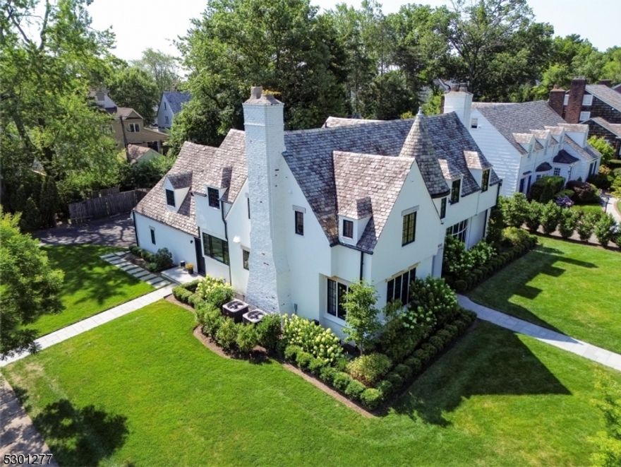 A rare opportunity to purchase a corner property on one of the most sought after streets in NJ. This beautifully updated & meticulously maintained 5 Bed, 3.2 Bath Tudor offers 5,000 SF (inc. bsmt) of living area, renovated w/ top-of-the-line materials & finishes. Step into the welcoming foyer, featuring wide plank white oak flrs w/ a stunning staircase that promises to impress from the moment you enter. The spacious family room retains its historic character w/ its original woodwork balanced w/ contemporary touches. The dining room features a built-in wine display & original dental molding. The kitchen has every bell & whistle; calacatta quartz counters, copious cabinets, waterfall island, 6 burner Wolf range, Sub-Zero refrigerator & beverage drawers, & a built-in banquette. Off the kitchen, you have a chic powder room & a cozy library w/ custom built-ins. Step into the bright sunroom overlooking the yard w/ large windows creating a seamless connection to the outdoors. The 2nd floor is also remarkable w/ a primary suite, additional bedrooms, jack-and-jill bathroom, & another bedroom w/ an en-suite bath great for guests. The primary bath features a soaking tub, XL shower, meticulous tile work, & a double vanity. The finished bsmt offers a 2nd living space/play area, utility room, 2 storage rooms, & a powder room. The fenced-in yard & pool area offer a great opportunity for customization. Please inquire for a full list of updates. *HIGHEST & BEST is due on Thurs 7/25/24 at 7PM.