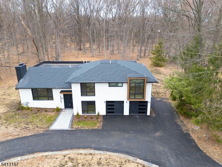 Custom unique expansive & open floor plan on 1. 8 Acres - Dramatic curb appeal from the circular driveway. Modern stucco & techwood vertical siding complements the black 8 ft European steel front door & oversized aluminum windows (coated & with argon for low E). Bright Sunlit Living room with gas fireplace. Home chefs dream KITCHEN - Breakfast area, huge Island, backsplash, cabinets, quartz counters & smart appliances. Dining room with additional seating area & a powder room. Steps down to a Family room. Guest bedroom with a bath on this level, laundry room & access to garage with tiled floors & EV charger. Master bedroom with ensuite & balcony. 2 other bedrooms & bath on this level. Organized closets & bathrooms have Bidets, LED mirrors & towel warmers. Finished LOWER LEVEL offers versatile options for indoor fun.  - Wi-Fi enabled thermostats for 4 zone gas HVAC, exterior lighting, cameras, door openers - hardwired TV outlets & ports. New 5" wide white oak flooring, accent walls, floating stairs, metal railings, solid doors, driveway, 200 Amp electric, insulation (even between floors & walls), plumbing, water softener & hot water heater. Huge Trex deck with gas connection for the grill. The incredibly private wooded backyard with no wetlands can host multiple outdoor activities -even tennis or hoops ! City utilities. Minutes to highways, NYC train, schools, shopping & restaurants. Reimagined for personal use & lovingly remodeled with the latest designer features & fixtures.