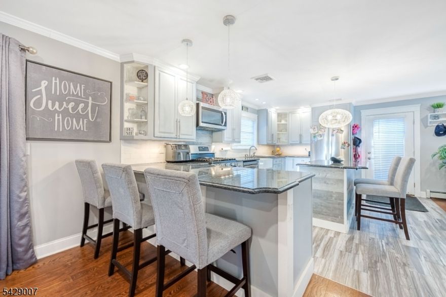 Welcome to this fully renovated, large Cape-style home offering 4 bedrooms plus 1  versatile bonus room, designed with space, flexibility, and true pride of ownership throughout. From the moment you step inside, you?ll notice the beautiful hardwood floors and custom carpentry details that add warmth, character, and a high-end touch to every room.The main level features a bright and open layout with a seamless flow between the living room, kitchen, and dining area, perfect for both everyday living and entertaining. Large glass doors fill the space with natural light and lead you out to a spectacular backyard with a covered patio, creating the ideal setting for gatherings and outdoor enjoyment. This level also includes a convenient laundry room and 1 bedroom on the main level, perfect for guests, extended living, or added convenience.Upstairs offers 3  spacious bedrooms along with 1 bonus room that can easily serve as an additional bedroom, home office, or flex space. The main bedrooms feature large closets, providing ample storage and comfort. An additional kitchenette area with a fridge and seating adds a unique level of convenience, ideal for multi-generational living or private guest accommodations.This home also includes a 1-car garage and is situated on a quiet dead-end street, offering privacy while being just one block from public transportation to NYC and close to major highways, shopping, and everyday conveniences.