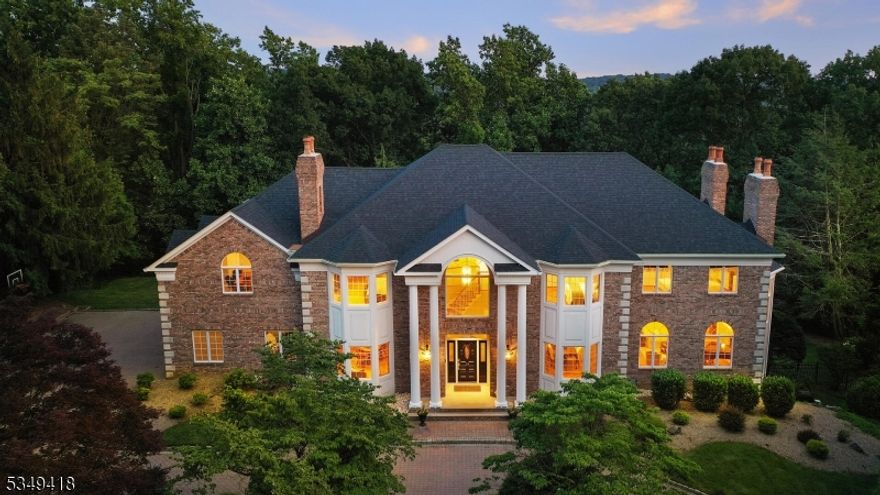 This custom, stately home is a masterpiece of design, boasting elegant architecture, a premier location on a private cul de sac, and a beautiful backyard with an in-ground pool and multiple entertaining areas offering views of the Watchung mountains, creating a truly exceptional living experience. There are 5 bedrooms, 5.1 baths, 5 fireplaces, 6,198 sq ft finished across 2 levels, and an additional 1,200 sq ft finished walkout lower level, 3 car garage, circular paver driveway, custom built with silent floors, cathedral ceilings, and tremendous natural light from the oversized windows. There is a spectacular lower level with 9.5 foot ceilings, fireplace, walkout, a full wet bar, full bath, and wall to wall windows. The first level features a two story foyer, a grand office with built in cabinetry, an elegant dining room and living room, a spacious en-suite bedroom and full bath, two story family room with floor to ceiling stone double sided fireplace, open to the chef kitchen with separate dining area, leading out to the deck for grand entertaining. The second level offers 4 bedrooms, all large in size, including a primary bedroom with sprawling bonus sitting room/office space, walk in closets, and a primary bathroom designed with luxury and functionality in mind. This home has it all! Just a few minutes to RT-78, shopping, top rated schools, including Pingry School, less than 30 minutes to Newark Intl Airport, close to train stations, and only 33 miles from lower Manhattan.
