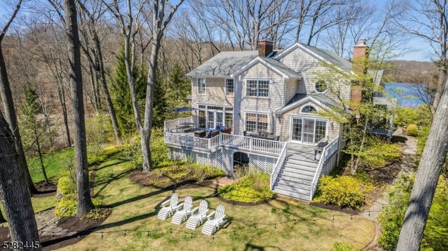 The most magical lakefront property in Mountain Lakes! Hidden on 1.13 professionally landscaped acres is your private peninsula overlooking not one, but two beautiful lakes. From your expansive multi-level natural wood deck, watch the sunset over Sunset Lake. Out the bedroom bay window, enjoy resplendent views of pristine Crystal Lake. From the gourmet custom kitchen, enjoy scenic views of both. This stunning, meticulously maintained 4,554 sq. ft. cedar shake home offers 6 bedrooms, 5.1 baths, an open floorplan, designer details, and exceptional craftsmanship throughout. A two-story foyer leads to the sun filled living room with one of 4 fireplaces and vaulted ceiling framing French doors to the deck and lake views. The adjacent spacious dining room opens to the butler's pantry and spectacular great room featuring a 5 x 12-foot natural stone fireplace. A delightful sunken octagonal seating area offers a 180-degree view of Sunset Lake and curated gardens. The chef's kitchen includes floor to ceiling white dove custom Mincraft cabinetry, double thick Carrera marble countertops, Sub-Zero refrigerator, Thermador Gas Range and Grill, and 8 ft. dark expresso island. Upstairs, French doors open to the luxurious primary suite with a sitting area, balcony, dream walk-in closet, and spa like bath with marble basket weave tile heated floors, soaking tub, and oversized frameless marble shower. Features include a sauna room, 2 laundries, whole house generator, dock, treehouse, and more!