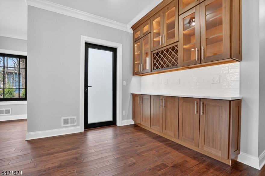 This stunning 5-bedroom, 5.1-bathroom new construction masterpiece seamlessly blends contemporary flair with timeless elegance. A grand two-story foyer entrance leads into an open-concept floor plan defined by high ceilings, rich hardwood floors, and an abundance of natural light coming through oversized, black-frame designer windows. A chef's kitchen is complemented by a sophisticated butler's pantry featuring integrated wine storage and illuminated display cabinetry. Do not miss the first floor ensuite bedroom. Architectural excellence is on display, from the sleek modern doors and custom millwork to the designer staircase accented by wrought-iron spindles. A magnificent primary ste with vaulted ceilings, huge walk-in closet. The spa-inspired primary ensuite is a retreat, boasting floor-to-ceiling book-matched porcelain, a deep freestanding soaking tub, and a curb-less glass rainfall shower. Each of the 4 bedrooms is generously proportioned, with access to designer-tiled full bathrooms for owners and guests alike. Walkout basement featuring a custom wet bar, wine cooler and a full bath along with a dedicated media/office room for cinematic experiences or quiet office. A perfect balance of suburban tranquility and modern convenience, situated just minutes from Westfield's award-winning schools, the vibrant downtown, and direct NYC commuter links. High-efficiency multi-zone HVAC and recessed LED lighting throughout. More than a home it is a lifestyle of unparalleled luxury.