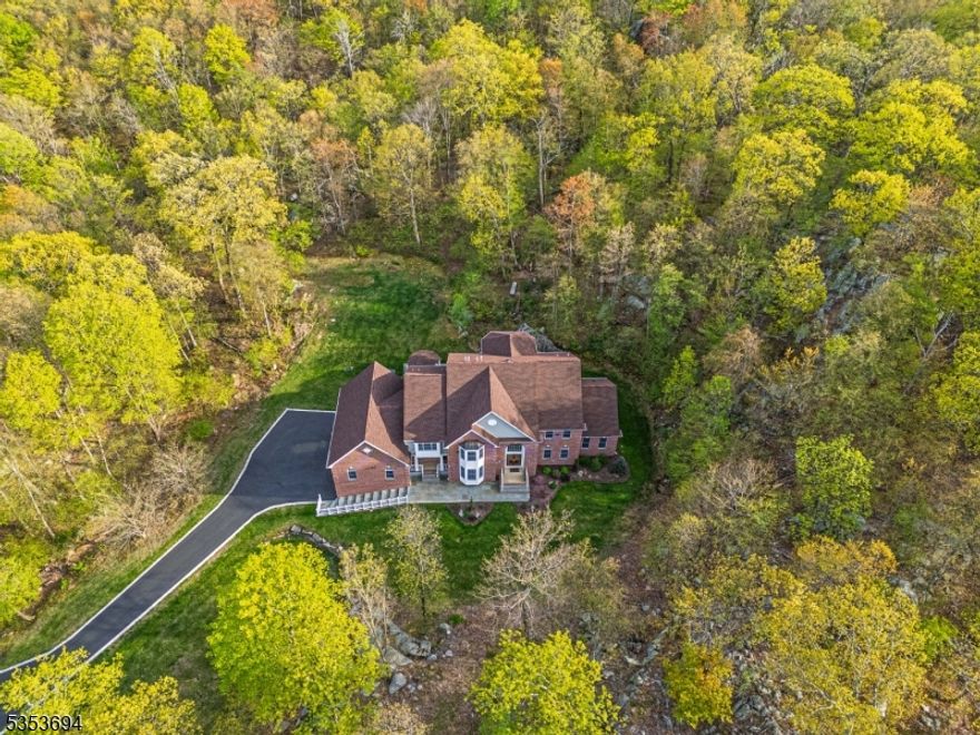 Welcome to this exceptional UPDATED custom colonial offering 5 bedrooms, 4.5 bathrooms, and over 5,400 sq ft of refined living space. A grand 2-story foyer with a sweeping staircase sets the tone, leading to a sun-filled conservatory, private office, formal living and dining rooms, and a dramatic great room with soaring windows and a gas fireplace. The gourmet kitchen features quartz countertops and opens to a new Trex deck. On the main level, you'll find a versatile in-law or primary suite with custom closets and a updated bathroom. Upstairs are four spacious bedrooms. The main primary suite includes a walk-in closet, separate vanity, separate sitting area, jetted tub, large shower, and dual sinks on opposite sides for added comfort. Another En-Suite, while two others share a Jack & Jill bath. This home has been thoughtfully updated with a NEW ROOF (2024), TWO 50-gallon Brand New Water Heaters (2025), Freshly Sealed Driveway, New W/D, Updated Central Vacuum (2025), New Landscaping, and a Full-House Backup Generator offering peace of mind year-round + so many more upgrades to mention. The finished walkout basement offers a kitchenette, dining area, gym, and game room. Outside, enjoy a professionally landscaped yard with a paver patio, fire pit, pergola, and serene wooded views. Located in the Estates of Kinnelon, just 35 miles from NYC and within a top-rated school district.