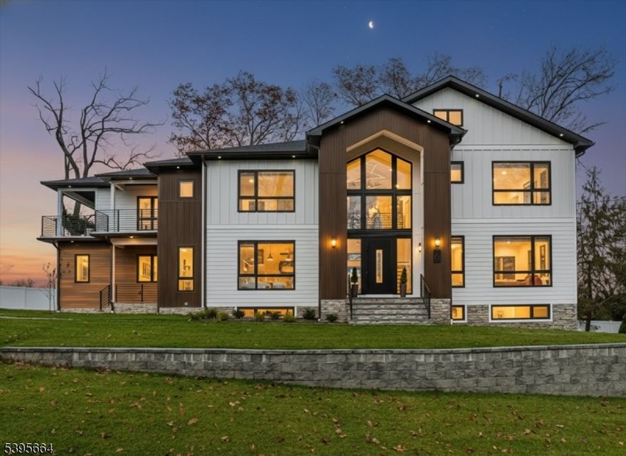 Experience Modern Luxury Redefined in this Stunning Masterpiece, Built and Designed by the renowned NJGCB, an award winning leader in Modern Architecture.  Nestled at the end of a quiet cul-de-sac, this New Construction home offers up both privacy & breathtaking water and golf course views. Thoughtfully designed w/ exceptional craftsmanship, this custom home features 6 beds, 6.1 baths, 3 Car spanning over 6,700 sq ft of finished living space. Grand foyer welcomes you with massive floor to ceiling windows, floating staircase & herringbone HW floors. The heart of this home is your gourmet kitchen, where every element was meticulously crafted.  Professional grade SS appliances, an abundance of sleek custom cabinetry, center island & walk-in Pantry.  Kitchen opens to an impressive 2 story Family Rm w/gas FP, soaring ceilings, skylights & oversized sliding doors leading to outdoor deck, perfect for Entertaining.  Elegant butler's pantry connects kitchen w/ Formal Dining Room, blending luxury with functionality.  A First Floor Guest Suite offers convenience & accessibility.  A beautifully appointed Primary Retreat w/ Covered Balcony, Custom Closets & Spa Inspired Bath w/dual showers & soaking tub. Three additional En Suite Beds & Laundry.  Above Ground walk-out basement, filled with sunlight includes Media Rm, Bedroom, Bath, Gym, Office, Wet Bar & Rec Room. Two sets of Sliding Doors leads to paver patio & fenced in yard w/room & approvals for future pool. Luxury Living at its Best.