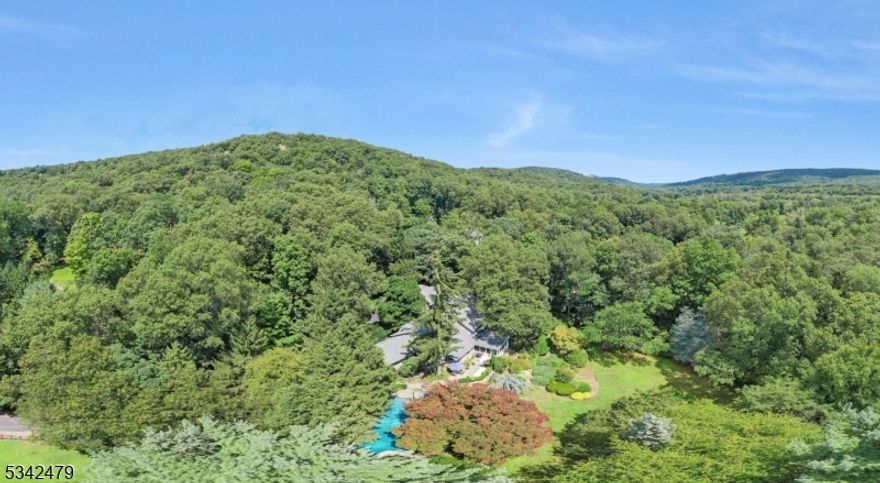 ESCAPE FROM THE ORDINARY to this SPECTACULAR PRIVATE COUNTRY ESTATE on 8.32 ACRES overlooking Ramapo River & majestic Ramapo Mountains. Perfect for those who love nature and privacy; just 28 miles from NYC. Such an ELEGANT HOME where open floor plan is ideal. Featuring a GRAND MARBLE ENTRY, custom glass railings, a DRAMATIC GREAT ROOM w/16 ft ceilings, a dual fireplace & wall of windows overlooking pool. A gracious DINING ROOM with french doors leads to a vaulted SCREENED PORCH. The GOURMET KITCHEN has Viking appliances and granite countertops. There are FIRST & SECOND FLOOR PRIMARY BEDROOMS w/en-suite bathrooms. A LUXURIOUS POOL & SPA are surrounded by expansive blue stone patios. PRIVATE EXTENDED LIVING QUARTERS offer one Bedroom, Kitchen, LR, BTH & sep Entrance. An additional stone structure, w/heat & a/c, once operated as a recording studio...personalize your own home office, gym, or studio here. DISTINCTIVE DESIGN. ONE-OF-A-KIND LOCATION. BE READY TO FALL IN LOVE!