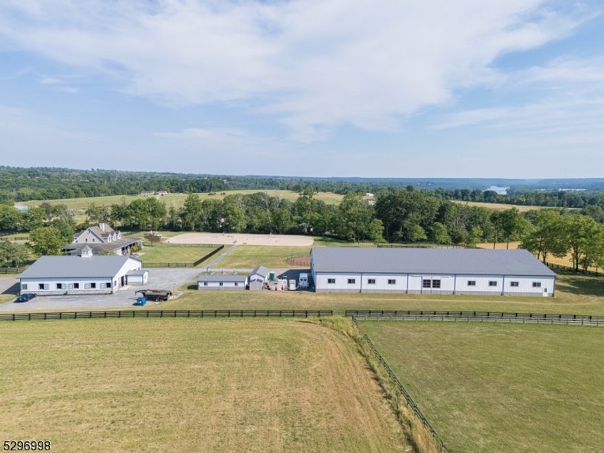 Experience the pinnacle of country living. This extraordinary 11+ acre custom estate in Alexandria Township boasts 360° panoramic views of Hunterdon and Bucks County! This property masterfully combines luxury residential design with professional grade horse facilities. The 3228 sq ft, 5 bed, 4 bath colonial was thoughtfully updated in 2021. It features a gourmet kitchen with a large center island, first floor primary suite with luxury bath,plus a junior suite with full bath. The layout includes a formal dining room, office, mudroom w laundry and wood-burning fireplace. Second floor offers 3 bedrooms, bonus room, laundry and full bath. A finished basement with 9 foot ceilings, private outside entrance, full bath and radiant heat serves as a perfect guest retreat. Amenities include whole house generator, multizone HVAC,and a oversized two car garage.  The equestrian facility is unparalleled. The insulated main barn features rubber pavers throughout, 9 stalls with therapeutic mats, fly spray system, camera system, LED lighting, heated tack room, lounge, and office, 2 wash stalls, and 2 tack stalls. Outside there are an additional six stalls with therapeutic mats, wash/tack area, bath and laundry. Training facilities include 80x180 indoor arena with TravelRight dust free footing, and LED lighting, 150x250 outdoor ring with GGT footing, and 70 foot round pen, with TravelRight footing, 9 hotwired paddocks, frost free hydrants, RV hook ups, perimeter bridle path, trails nearby.