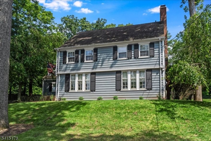 Timeless Colonial Charm with Exceptional Outdoor Living. Welcome to this beautifully refreshed 6-BR, 4.2-BA Colonial, gracefully set on nearly a half-acre lot that commands impressive curb appeal from the moment you arrive. Nestled in Verona's sought-after Afterglow neighborhood, named for the stunning sunsets that wash its wide, tree-lined streets in golden light, this grand and airy residence blends classic Colonial character with thoughtful modern updates throughout. The striking blue-gray exterior with crisp black shutters, brick chimney, and lush hillside lawn creates a storybook first impression. A welcoming stone-stepped entry leads inside to light-filled, generously proportioned rooms designed for both everyday living and effortless entertaining. Step outside and discover a truly exceptional private backyard retreat. A classic herringbone brick patio flows seamlessly into sweeping green lawns, mature shade trees, and a charming fire pit circle - perfect for al fresco evenings. An oversized detached two-car garage completes the grounds. Recently refreshed and move-in ready, this home offers the rare combination of space, character, and outdoor living that today's buyers dream of. The Afterglow neighborhood borders Montclair directly, putting one of New Jersey's most vibrant and desirable communities with its NYC-bound transit, top dining, and thriving arts scene right at your doorstep, all with Verona's meaningfully lower property tax rate and top rated schools!
