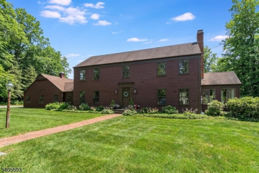 Set back from the road, a long, tree-lined drive leads to this custom-built Colonial, situated on approximately 15 acres of open land and mature woodland. The setting offers exceptional privacy, wide-open yard space, and peaceful country surroundings yet remains remarkably convenient to Routes 78 and 22 for easy daily access. Designed to capture both comfort and views, the home features a traditional Colonial layout enhanced by thoughtfully added living spaces. A first-floor office provides ideal work-from-home flexibility, while the three-season room invites you to relax and take in the rolling landscape beyond. Throughout the home, quality craftsmanship is evident in the solid wood doors, detailed woodwork, and hardwood flooring on both the main and upper levels. The main level includes a full bathroom and a welcoming living room centered around a wood-burning fireplace. Upstairs, the primary bedroom offers a private retreat with a walk-in closet and a full en suite bath. Many rooms throughout the home were intentionally positioned to showcase scenic views of gently rolling hills and the surrounding countryside. With direct, step-free access from the garage into the home and a setting that balances seclusion with accessibility, this property presents an exceptional opportunity for those seeking space, privacy, and timeless design in a truly serene environment. Taxes and assessments are total of multiple lots and are approximate.