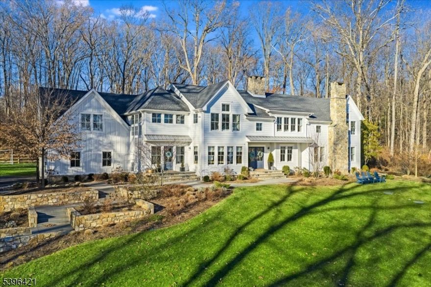 This masterfully re-imagined custom built Farmhouse style Colonial blends classic architecture with refined country living in the coveted town of New Vernon in Harding Township. This re-designed home was completely re-built from the foundation up in 2022. A spacious light filled, comfortable and chic living space has been created containing six en suite bedrooms including a first fl. primary bedroom suite w/ laundry & sitting rm/office.. Dbl. doors open to front foyer. The main gathering areas span from entrance to family room which opens to  great room.This generous space anchored by a stone FP includes custom wet bar cabinet & black steel french doors to terrace. The epicurean kitchen fitted with white oak cabinets, upper end appliances, oversized island & dbl. sided FP. Adjacent are the butlers pantry & mudroom. Cathedral ceiling in rear/side foyer w/ 2 story window and staircase to 2nd floor leads to 4 en suite bedrooms, laundry room and den/game room. Finished generously sized LL contains family room w/wall mounted TV, play area, billiard area, finished room/home office, full bathroom, gym/exercise room  with rubber flooring & wall mounted TV, 3 mechanical rooms/closets. Bluestone terrace on level rear yard with multiple access points from home. Custom built stone wall and steps to front and side entrances.