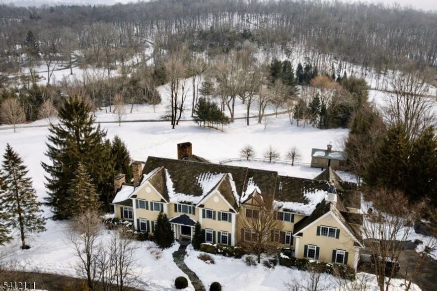 Set behind a gated entrance on 9+ private acres, 89-91 Mosle Road is a rare dual-residence estate offering luxury, privacy, and resort-style living. The 7BR, 8.1BA main house (91) features a dramatic 2-story foyer with herringbone floors, elegant formal rooms, a cherry-paneled office, and a stunning sunken great room with coffered ceiling and fieldstone fireplace. The newly reimagined 2024 Arclinea chef's kitchen is a showstopper with Wolf/Sub-Zero/Cove appliances, oversized island with dining table, built-in coffee bar, and separate prep kitchen. A private primary wing offers fireplace, multiple walk-in closets, and a spa-like bath with heated floors and Porcelanosa fixtures. The walk-out lower level includes a pub-style bar and billiards room, wine cellar, media/recreation space with projector, gym, and abundant storage. The 3BR, 4.1BA guest house (89) is a modern farmhouse retreat with 12' ceilings, cathedral living room with barnwood beams, two-story double-sided fieldstone fireplace, and walls of windows overlooking the grounds. Designer kitchen with marble counters and Bertazzoni range, first-floor primary suite, upper-level loft and en-suite bedrooms, plus a full gym and dedicated altitude training room. Resort-caliber grounds include expansive bluestone patios, heated pool with spa, fully equipped pool house, gated drive, lush lawns, and exceptional privacy in the heart of the Somerset Hills.
