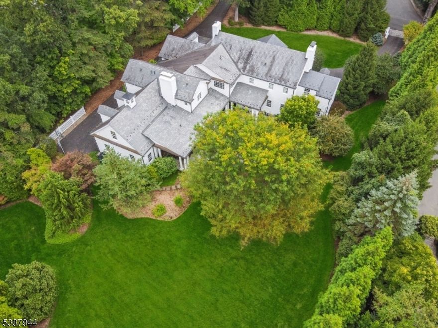 STUNNING & STATELY * PRIME OLD SHORT HILLS LOCATION * Set atop over-an-acre of beautifully landscaped property, this spectacular 1936 Colonial was completely gut-renovated and expanded to-perfection creating an easy-flowing floor plan with high-end finishes, designer lighting and unparalleled attention to every detail. Enter gracious foyer with rounded staircase to find a refined LR, sun room/office & elegant DR with bespoke wood paneling. Library, gourmet kitchen, bar/conversation area & FR w/ fireplace boast floor-to-ceiling French doors offering views of the expansive property. Gourmet kitchen is a culinary masterpiece, featuring custom cabinetry, ss appliances (SubZero/Miele/Marvel), island w/ seating, farm sink & walk-in pantry. Laundry room, mudroom & att garage provide effortless living. Upstairs, lux primary suite is a true retreat with custom closet, office & a spa-like bath w/ heated flrs. LL: rec rm w/ wood bar, wine cellar, fab exercise rm. Step outside & prepare to be WOW-ed by Bluestone patios, outdoor kitchen & covered porch w/ FP that overlook open lawns & manicured grounds w/ exten landscape lighting (room for pool!). Slate roof ('24&'07), new HVAC ('23), Pella windows, sec sys ('25), invisible dog fence & Sonos-ready speakers inside & out * 61 Taylor Road is close to everything: Short Hills trains (0.7 mi), Glenwood Element (0.4), Arboretum (0.5) & just 15 mins to EWR.  A rare opportunity to own a legacy property in the heart of Short Hills. Welcome Home!