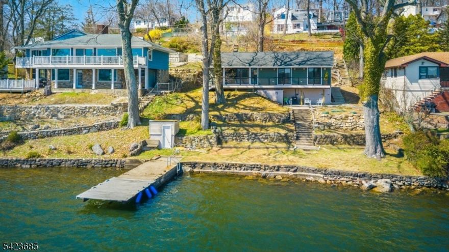 Welcome to your dream lakefront retreat! If Mid-Century Modern is your vibe, then you must see this renovated lakefront home. A new roof, siding, deck, windows, central air, electric, kitchen cabinets, quartz counters, and appliances were completed in 2024. The septic is  2022.  The bathrooms were preserved to keep the integrity of the MCM aesthetic. All rooms except one have deep water views. The dock is 30 feet long and can accommodate any size boat. Nearby Elba Beach Club can be joined for a nominal fee.  Enjoy seamless indoor-outdoor living with direct access to the lake, ideal for kayaking, fishing, or simply relaxing by the water. Whether you're sipping your morning coffee on the deck or hosting sunset gatherings, the setting is truly unmatched. Perfect as a year-round residence or weekend getaway, this move-in-ready lakefront gem comes completely furnished and delivers comfort, style, and a lifestyle you'll love.