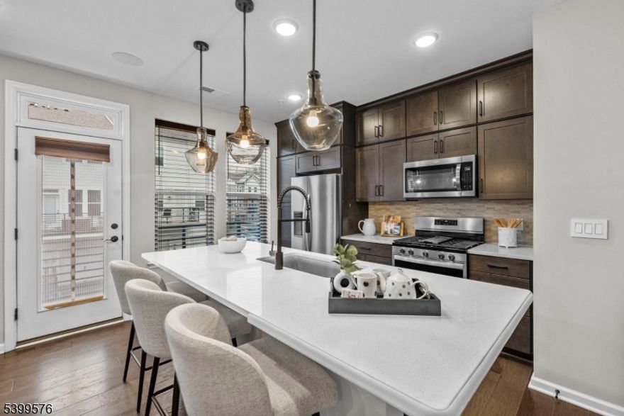 Discover modern living in this 2022-built 3 bedroom, 2.5 bath townhome located just 30 minutes from New York City. Perfect for commuters, this home offers quick access to the train station to NYC, a private 1-car garage, and EV charging capability. The open concept main level features a chef inspired kitchen with stainless steel appliances, quartz countertops, upgraded cabinetry, and a seamless walkout to a private deck, ideal for entertaining. The spacious primary bedroom suite includes a custom walk-in closet, double vanity en suite, and upgraded tile and fixtures for a true luxury feel. Enjoy resort style community amenities, including a fitness center, swimming pool, tennis courts, billiards room, and an elevated rooftop entertainment area. With modern finishes, smart layout, and exceptional commuter convenience, this property is the perfect choice for buyers searching for a luxury townhome near NYC, new construction townhome, or move-in ready home with amenities.  Not to mention low taxes with a 30yr Pilot Program.