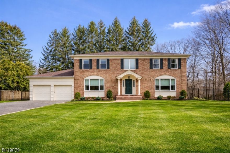 Set on a picturesque cul-de-sac in the prestigious Convent Station section of Morris Township, this impeccable Center Hall Colonial offers timeless elegance and refined living. The beautifully maintained brick exterior provides exceptional curb appeal and a welcoming sense of arrival.  An open, inviting foyer with hardwood floors throughout leads to a spacious family room featuring a stunning fireplace, oversized windows, and abundant natural light perfect for everyday living and entertaining. The formal dining room off the kitchen is ideal for holidays and special gatherings. The all-white kitchen offers granite countertops, stainless steel appliances, a stylish dry bar, wine refrigerator and ample cabinetry. A half bath, convenient laundry/mudroom completes the first floor.  Upstairs features four generously sized bedrooms and a full hall bath. The primary suite includes a walk-in closet, 2nd closet, excellent storage, and a spa-like bath with soaking tub and separate shower. The finished basement provides additional living space with a recreation area, flex room, and abundant storage.  Enjoy a serene backyard with privacy trees, a large deck and expansive green space. Located close to schools, the park, downtown shopping, and the Midtown direct NYC trains just a five-minute walk to the Convent Station. This home offers luxury, comfort, and convenience in a coveted location.