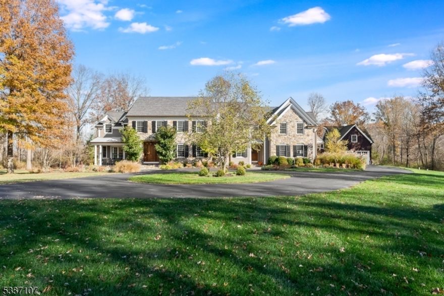 Nestled in eastern Mendham's Washington Valley, this stunning custom home offers a blend of sophistication and modern luxury. Built-in 2007 with updates in 2014 and 2019, the home sits on 3 level acres bordering serene parkland, yet just moments from vibrant downtown Morristown. The cedar and natural fieldstone exterior, with a dramatic circular driveway, is inviting. Inside, the 5-bedroom residence is a testament to fine craftsmanship. Extensive custom moldings, millwork, six-panel wood doors, and hardwood floors flow throughout the home. The light-filled, thoughtfully designed floor plan is ideal for both large parties and intimate gatherings. A spacious gourmet kitchen features top-of-the-line appliances, ample workspace, and seamless access to the home's indoor and outdoor entertaining spaces. The second-level primary suite is a retreat, boasting a stone wall with fireplace, sitting room, sumptuous bathroom, and dual custom closets. Each additional bedroom is en-suite, ensuring privacy and comfort. The home's lower level boasts a rec room, exercise room, media room, wine cellar, and powder room. Outdoor living reaches new heights with a heated pool and raised spa with waterfall, a gas fire pit, grilling station, and open lawns. Additional features include a 3-bay attached garage, a carriage house with 2 garage bays with an unfinished second level. Enjoy proximity to award-winning schools, equestrian facilities, world-class golf courses, shopping and dining, and NJ Transit