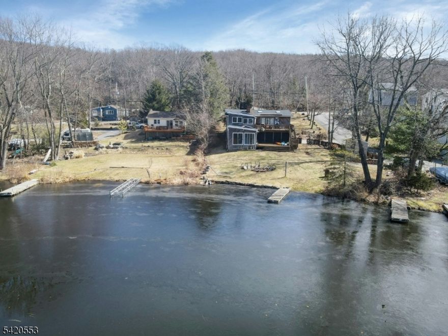 Lakefront Opportunity! Ready to make this home your own, offering approximately 3,000 square feet of living space and exceptional views of Upper Greenwood Lake.Rare opportunity to own a true lakefront property with direct water access. This home presents incredible potential to create a custom retreat, with many major improvements already completed. Recent upgrades include a new roof (1 year old), septic system, well pump and tank, and water heater, providing peace of mind for key components.The main level features high ceilings and hardwood flooring throughout, creating warmth and continuity across the living spaces. The lower level offers walk-out access to the lake, providing a seamless connection to the outdoors. A wall of windows along the lakeside fills the space with natural light and captures beautiful water views.The layout offers a natural flow, ideal for both everyday living and entertaining. Situated on a corner lot, the property includes ample parking with a front driveway, a private side driveway, and an attached two-car garage.The home features 3 bedrooms and 2 full bathrooms. The primary suite includes an additional lakeside room with expansive windows and a spiral staircase leading to a large bonus space, creating a flexible and unique living area.With its premier waterfront location, generous square footage, and key structural updates already in place, this property offers a rare opportunity to design and finish a true lakefront home to your vision.