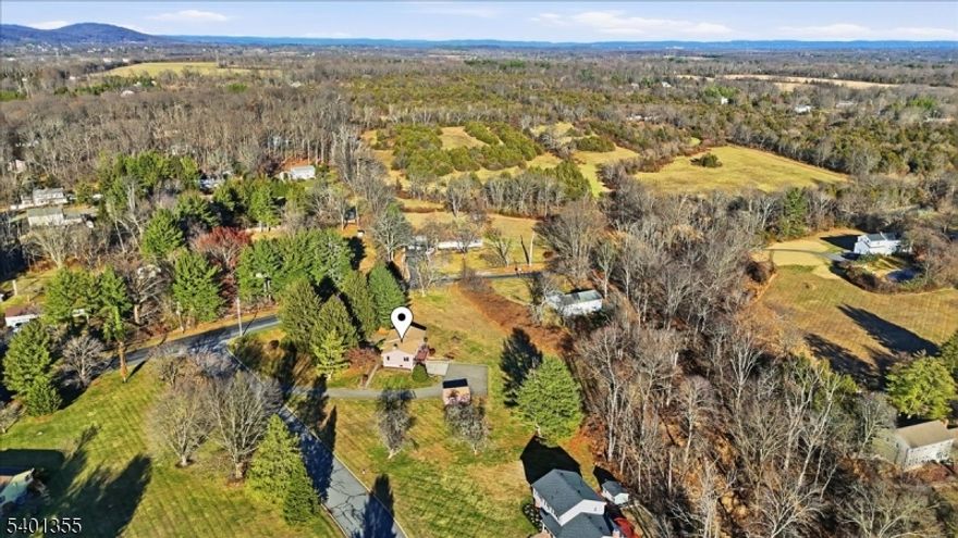 Located in a picturesque cul-de-sac neighborhood, this raised ranch is nestled on a beautiful open lot flanked by mature trees & peaceful surroundings. Notable features include exposed wood beams, abundant natural light, natural stone features & an open floor plan. Step inside to find a cozy yet spacious living area w/wood accents, vaulted ceiling, wood floors & large windows that frame tranquil outdoor views. The kitchen is bright & functional, boasting ample cabinetry & plenty of counter space. The highlight of the living room is the stone fireplace w/wood burning insert providing additional heat & bay windows overlooking the front and backyard. Completing this level is a dining room, 3 bedrooms, & 2 full bathrooms including a full bathroom in the primary bedroom. All bedrooms have large closets & the primary has 2 closets (one is a walk-in). The ground level has large rec room, laundry area, & access to the 2 car garage. Outside enjoy views from your deck & freedom of open space. Updates throughout the recent years include roof, wood floors, windows, shed, cedar siding, paved driveway, well pump & retractable awning. Natural gas in street. This property offers a rare blend of location, charm & convenience. Located near routes 31, 202, 22 & 78, & just an hour from NYC & Newark Airport. Near public transportation via NJ Transit trains & Trans Bridge bus. Minutes to shopping in Flemington & Whitehouse Station. Don't miss this opportunity to own a slice of country paradise!