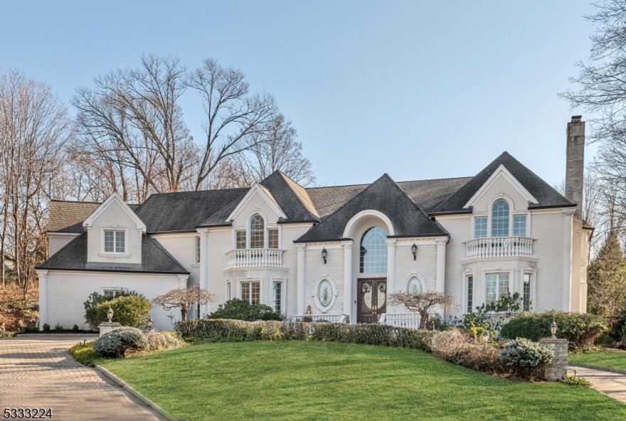 Discover unparalleled luxury and refined living in this exquisite custom-built all-brick home, perfectly situated at the end of a premier cul-de-sac on 1.4 lush, private acres. Designed by the renowned Leonard Divak, this 6,600+ sq. ft. residence effortlessly combines timeless elegance with modern comfort and warmth. Step through the grand entryway, where soaring ceilings and breathtaking bridal staircase create an unforgettable first impression. Entertain in the banquet-sized DR w/butler's pntry and LR w/cozy fpl. The home's perfectly flowing floor plan continues with the chef's kitchen incl granite counters, custom cabinetry, SS appl, and center island. The kit opens seamlessly into the dramatic Gr Rm, showcasing 20' ceilings, wet bar, and impressive fpl. A 1st fl office w/full bth offers flexibility as a guest suite/br. A family/media rm, mudrm w/lndry, and 2 PR's complete the main level. Upstairs, the primary suite is a lux retreat, w/tray ceiling, 2 WIC's and bth w/double vanity, soaking tub/separate shower. Three addt'l en-suite br's and a balcony overlooking the Gr Rm complete the 2nd fl. The beautifully landscaped backyard offers a private oasis, featuring a spacious patio, built-in BBQ, 2 retractable awnings, and majestic waterfall feature! The att grade-level 3-car gar and paver circular drive provide ample parking. Special features incl 1st fl lndry, HW and marble flrs, IG-irrigation, sec sys, surround sound throughout (Note: town verified 4 br septic).