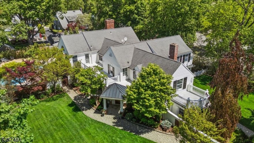 Elegant Custom Colonial in historic and thriving Morristown, offering exceptional privacy just blocks from acclaimed restaurants, shops, cultural venues & direct train to NYC. Set on a beautifully landscaped lot, this gracious 6-bed, 4.5-bath and 3-car garage combines timeless architectural charm with a spacious layout shaped by 2 thoughtful additions, creating a distinctive fusion of classic design & contemporary style. The main level features hardwood floors, a great room, formal dining room, and an indoor sunlit grill room with built-in stainless grill. The gourmet eat-in kitchen includes wood cabinetry, high-end appliances, including a Wolf range with pot-filler and center island. A coffered-ceiling family room opens to a bright sunroom, full bath, and screened-in porch. A private office with separate entry and a powder room enhances the home's functionality & elegance. The upper level hosts the primary suite with vaulted-ceiling sitting area, balcony & spa-like bath with jetted tub+stall shower. A junior suite with fireplace, plus 4 more bedrooms & laundry room, complete this level. The partially finished basement provides additional storage & flexible space. Step outside to a resort-like haven designed for both relaxation & unforgettable gatherings, featuring a paver patio, lush landscaping, in-ground Gunite pool with jacuzzi+waterfall, and a charming cabana. A rare opportunity to own a spacious, character-filled home in one of Morristown's most coveted neighborhoods.