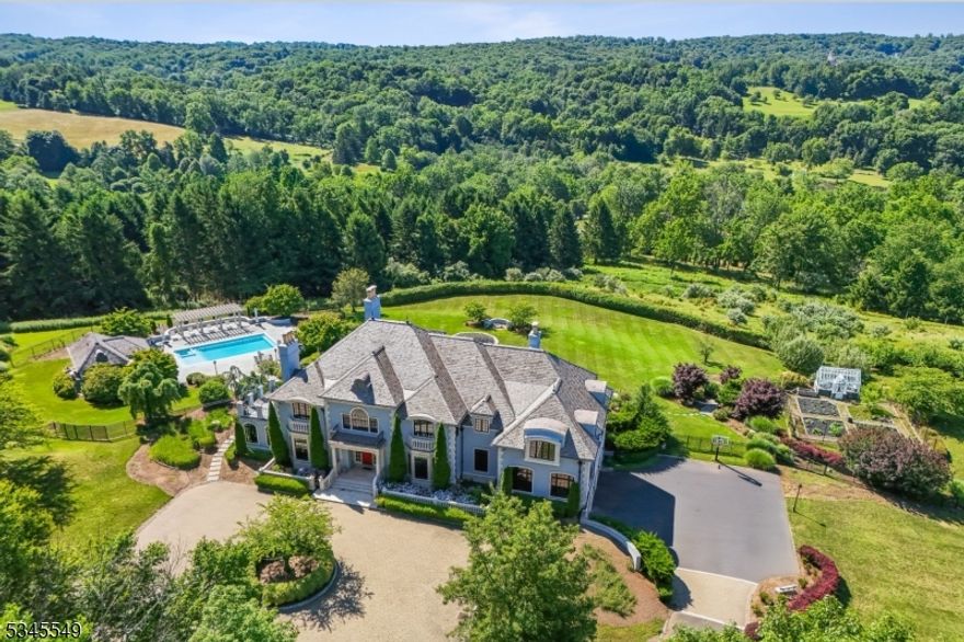 Originally modeled after the grandeur of the Palace of Versailles and nestled in a serene setting with breathtaking views from every angle, this exquisite 6-bedroom estate was completely transformed in 2020 to a modern architectural masterpiece. A private gated drive winds up to this extraordinary residence, with impeccable attention to detail in every corner. Designed to impress, this home offers a perfect blend of opulence & comfort, ideal for both grand-scale entertaining & intimate gatherings. Step outside into the stunning manicured gardens, where lush greenery & vibrant blooms surround you. Adding to the charm is an authentic English greenhouse, with its own dedicated water supply, ideal for nurturing your favorite plants year-round. The estate also boasts a sprawling apple orchard, offering seasonal fruit & a peaceful countryside atmosphere. The remodeled pool area provides the perfect oasis. A fully equipped pool house features a full bath & kitchen, making it ideal for both hosting poolside gatherings or enjoying a day of relaxation. Inside, state-of-the-art systems further elevate the home's appeal, including a Savant home automation system, sophisticated video security system & a high-end home theater. A built-in generator ensures that these luxuries continue uninterrupted. This remarkable estate offers an exquisite lifestyle for those at the pinacle of success, where every turn presents beauty, luxury and an escape from the ordinary.