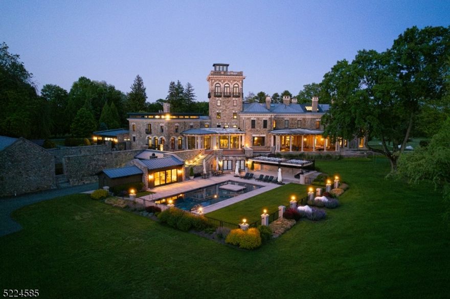 Rarely does a property come to market that melds the rich heritage of 19th century Somerset Hills and the ultimate in modern form and function of the 21st century. The home has been brilliantly reimagined to meet today's updated wants and needs. Set amid 32 lush acres, this majestic residence is an architectural masterpiece. The original interior appointments of the home have all been painstakingly restored with the greatest of care. The whimsical and eclectic interior design is the perfect counterpoint to the home's classical architecture. The thoroughly modernized and expanded kitchen adjoins a breakfast room and comfortable two-story family room and provides the ideal setting for day to day life. A wall of glass doors brings the outdoors in and leads to a terracotta terrace with outdoor kitchen and stairs that lead to the pool, pool house and grounds. A most unique feature of the home is the tower offering a sophisticated lounge/bar as well as a breathtaking office and rooftop deck with views as far as the eye can see. The home has a Savant Smart Home System and can be remotely controlled via smartphone. The swimming pool with limestone deck, covered cabana and pool house with kitchenette and wood burning fireplace, overlook this stunning property. There is also a full property generator and elevator to 6 levels of living, a carriage house with 3 beds, 2.1 baths and 5 car garage and a gymnasium with full-sized basketball court, workout room, kitchenette and change rooms.