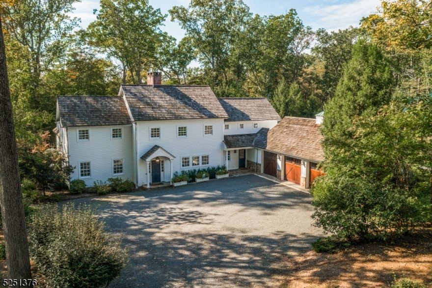 A classic Colonial gem is sited on 10 farm-assessed acres in Far Hills, where it backs to Natirar Park's scenic hiking trails and open space. Finished in HardiePlank siding and capped by a cedar shake roof, this beautifully maintained home was expanded and updated in 2006. The five-bedroom, Five-bath layout is enhanced by an attached three-car garage, heated gunite pool, bluestone and antique brick patios, paver block firepit, built-in grill station, and two-stall storage barn. Set on a quiet cul de sac and approached by a stone drive, the stunning architecture is surrounded by green lawns, lush landscaping, and mature trees.