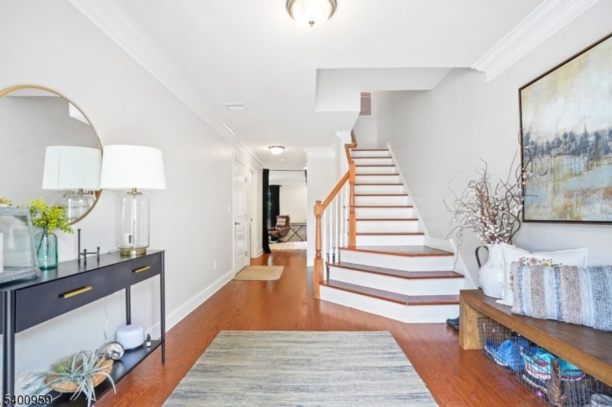 Beautiful townhome located in highly desirable Mountain Lakes, offering top-rated schools, convenient access to shopping, the Mountain Lakes Train Station, and major highways. This home provides the ease of maintenance-free community living with an open concept floor plan perfect for both entertaining and everyday comfort. The first level features a spacious recreation room that opens to a lovely private patio. On the second level, you will find a gourmet kitchen with granite countertops, a large center island, and stainless steel appliances, along with direct access to a deck for outdoor enjoyment. The kitchen flows seamlessly into an impressive great room with high ceilings, expansive windows, a gas fireplace, and a generous dining area. The third floor offers a magnificent owner's suite with an elegant bathroom and a custom walk-in closet. Two additional bedrooms, a well-appointed main bath, and a conveniently located laundry complete the upper level. Hunter Douglas blinds are featured throughout the home.  Bedrooms have been virtually staged