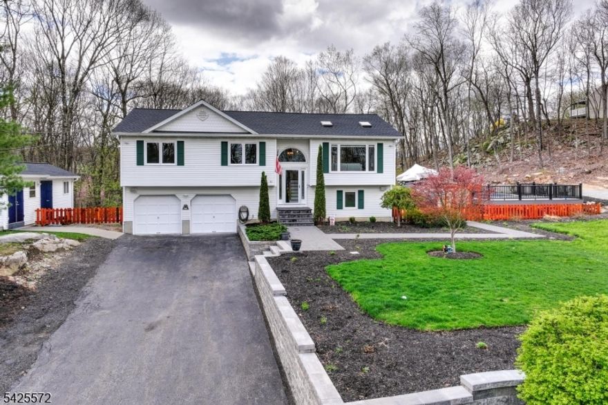 Live The Lake Lifestyle in this beautifully updated oversized bi-level designed for gathering, relaxing, and enjoying the outdoors. Vaulted ceilings and an open-concept layout create a bright, airy feel, while triple decks and an oversized 2-car garage with additional parking for up to 20 cars make hosting effortless. Nearly every detail has been upgraded, including a gorgeous kitchen with newer stainless appliances, center island, and granite counters. Stunning new primary and main baths with white quartz and custom tile finishes. New LVP flooring, custom solid doors, oak and frosted-glass railings, and a new front entry with Andersen storm door. This home blends modern style with warm, natural touches like a solid white oak mantle, fresh paint, and cedar fencing. Step outside to your own private retreat: a Trex Whidbey composite pool deck with lighting, a 15-ft above-ground pool, hot tub hookup, new hardscaping, sprinkler system, landscape lighting, and multiple outdoor spaces perfect for summer barbecues or quiet evenings under the stars. Major improvements include a new roof, new furnace, pellet stove, new back windows, high-efficiency Navien on-demand water heater, new well pump and pressure tank, newer central air with insulated ducting, and generator panel. Bonus room with electric adjoining shed. Close to Skiing at Mountain Creek and Crystal Springs Golf. Move-in ready, thoughtfully upgraded, this home offers the space, comfort, and lifestyle you've been looking for!