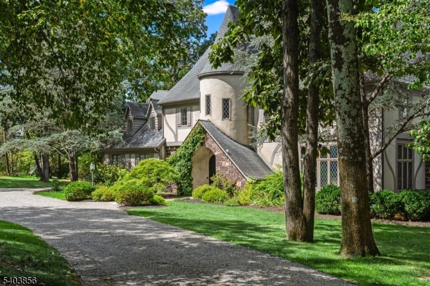 Tucked away in picturesque Far Hills, within an hour of Manhattan, this updated French Normandy Tudor-style residence, set on 14 acres, is a rare architectural gem, blending storybook charm with timeless sophistication. From the long private drive, the signature turret entry immediately sets the tone, with diamond leaded-glass windows and classic European detailing. The facade showcases hand-laid fieldstone, half-timbering, smooth stucco, and steeply pitched rooflines. Inside, the light-filled home offers 9 -ft ceilings, spacious rooms, hardwood floors, updated baths, and finely crafted details. The dramatic entry hall has a soaring 36-foot turret, exposed beams, patterned flooring and curved staircase. Living spaces include a stunning, generously scaled living room, a large dining room, a wood-paneled library with fireplace, and a chef's kitchen. The adjacent family room with fireplace opens to an expansive rear deck overlooking the pond. Upstairs, four to five bedrooms include a luxurious primary suite with two walk-in closets and dual updated baths. A finished walk-out lower level adds a family room, office, gym, game room, wine storage, full bath, and laundry. The grounds feature mature trees, lush landscaping, a one-acre pond with a fountain, a gunite pool and spa, a tennis pad, a heated 10-vehicle car barn, and deer fencing. Close to the village, NJ Transit, major highways, world-class golf, dining, equestrian facilities and just 30 mins to Newark Liberty Int'l Airport