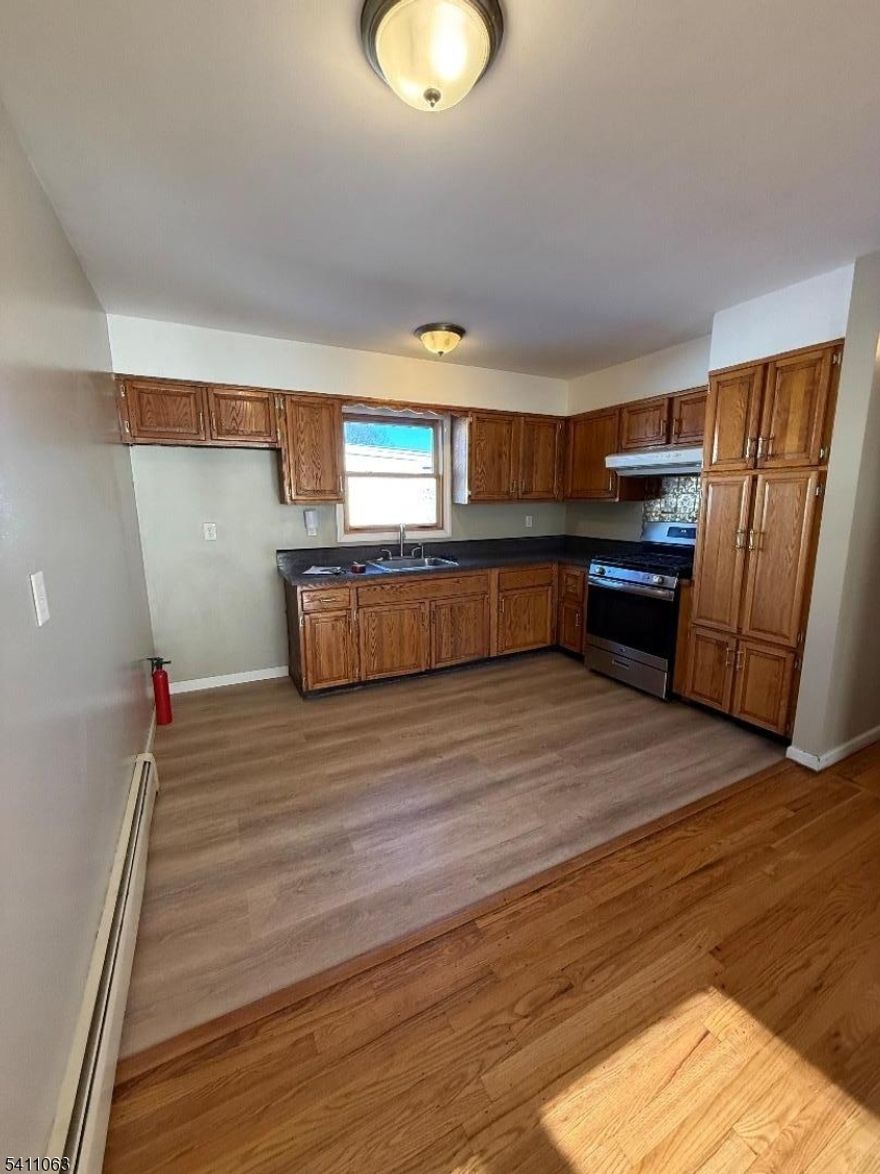 A spacious three-bedroom apartment boasts exquisite hardwood flooring throughout, recently repainted, and a generous living room. It also features a formal dining room, an updated tiled bathroom, and access to a fenced-in yard. Parking is conveniently available, and the apartment is centrally located near New York City?s transportation hub.