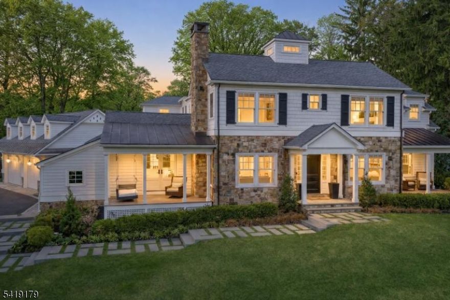 A seamless blend of refined design and thoughtful layout defines this beautifully crafted home, offering an ideal balance of elegant entertaining spaces and effortless everyday living. The main level features a spacious eat-in kitchen that flows into the family room and extends directly to the expansive patio, creating a seamless indoor-outdoor connection ideal for both daily living and entertaining. A formal dining room, living room and private den provide distinct yet cohesive spaces for gathering or quiet retreat, while a first-floor bedroom offers flexibility for guests or office use. A well-appointed mudroom and laundry area connects directly to the garage, adding functionality and everyday ease. Upstairs, the primary suite serves as a private sanctuary with generous proportions, generous walk-in closet and spa-inspired bath designed for relaxation. Additional bedrooms are well-sized and thoughtfully positioned, including one with charming architectural lines, built-in window seat and dedicated workspace. A central study area and second-floor laundry enhance comfort and convenience. The finished lower level offers a spacious recreation area ideal for entertaining or relaxing, along with additional storage options. Outdoors, the patio is anchored by a fire feature and multiple seating areas, creating the perfect setting for gatherings. The expansive lawn beyond offers room for recreation, framed by mature trees that provide both privacy and a serene natural backdrop.