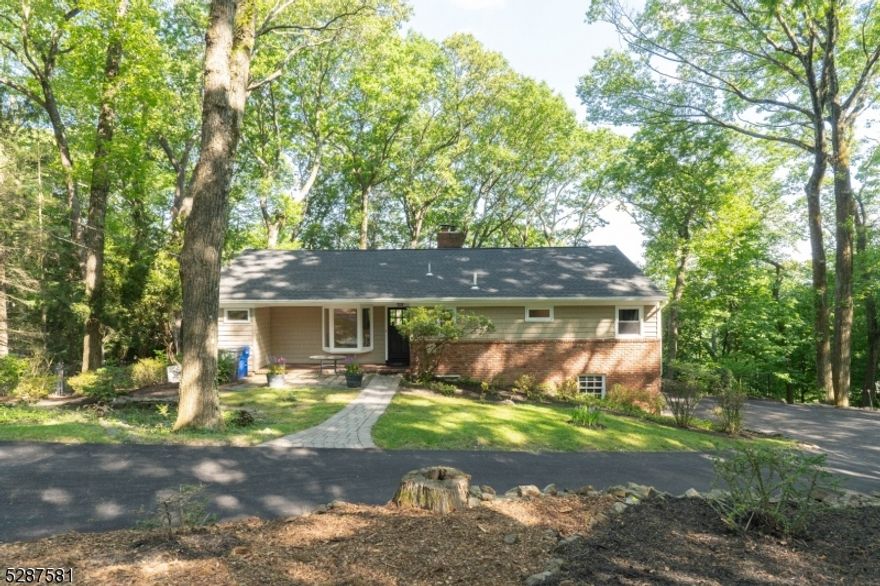 Welcome to your sanctuary nestled amidst breathtaking mountain views in a treehouse-like setting. This raised ranch boasts a light-filled interior with hardwood floors throughout, inviting the outdoors in through plenty of windows. Step onto the two-tiered deck and soak in the natural beauty that surrounds you. The heart of the home lies in the updated kitchen, boasting granite countertops, a breakfast bar, soft-close drawers, and a huge pantry for ample storage. First floor laundry is also a plus. Inside, discover a spacious layout featuring 3 bedrooms and 3 full baths, perfectly complemented by a 2-car garage for convenience. The master bedroom suite is a true retreat with a  huge picture window to capture stunning vistas complete with a new spa-like bathroom. The lower level offers additional living space, including a bedroom, full bath, and a cozy wood-burning fireplace for chilly evenings. Indulge in relaxation in the hot tub room, creating the ultimate oasis at home. Outside, a new blacktop driveway adds to the curb appeal of this charming residence. Don't miss the opportunity to experience the tranquility and luxury this home has to offer. Hot tub and fireplace as-is.