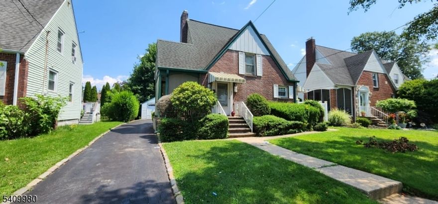 This property features a front lawn and a side porch. The ground level offers an entry living and dining area, a kitchen, and two side entrances providing access to the backyard and deck. The upper level includes two bedrooms and a full bathroom. The unfinished basement provides additional storage space and includes a washer and dryer. Additional features include driveway parking and central air conditioning.