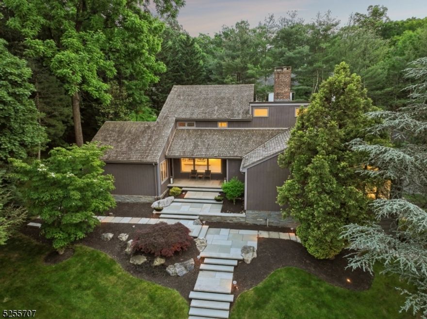 Hollywood Hills meets Summit's Northside! This dramatic contemporary gem is a piece of art that you live in. Walk up the floating pathway and step inside to find a spacious living room that features a gas fireplace and a wall of windows. Across the foyer there is a generous dining room with high ceilings and easy access to the gourmet kitchen. The heart of the home is the fabulous kitchen with breakfast room. The kitchen has quartz counters, professional, stainless steel appliances and is fully open to the breakfast room, large deck & stunning side yard. Off the living room is a family room and 1st floor office/ bedroom, a convenient mudroom, powder room & guest suite. The deluxe primary suite has a luxurious bath w/ soaking tub, glass shower, double vanity & private deck. Upstairs find two more bedrooms and a full bath. The LL offers so much added living space including a recreation room, sauna, full bathroom, laundry room and storage. Step outside to the gorgeous deck and park-like yard with specimen plantings and wide open lawns-- perfect for outdoor relaxation and play. MORE: freshly painted, refinished floors, sprinkler system, security system, oversized garage & dog fence. Walking distance to the Summit train station and all that Summit has to offer. 10 Beacon Road is a wonderful property in an A+ location. Welcome Home!