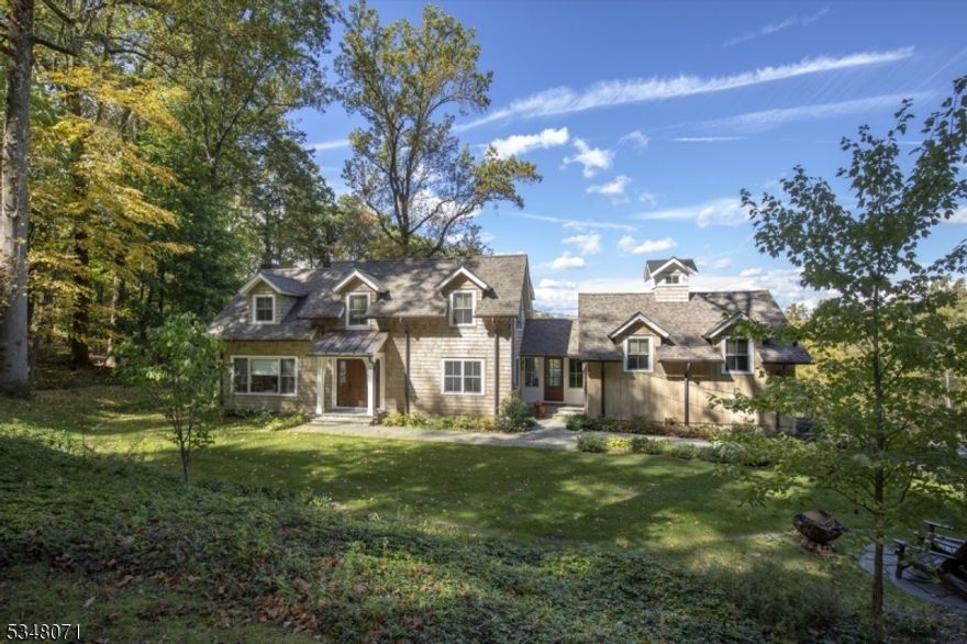 Re-built by Scandic Builders in 2020, "Valley View"  boasts breathtaking distant views of the valley and exceptional craftsmanship at every turn. The wood shingle exterior with copper accents and architectural details sets the tone for this one-of-a-kind setting. Designed for today's living with a smart floor plan, detailed moldings, custom built-ins, and the finest of finishes. Inside, white oak floors and neutral stone tiles create a unified look throughout. Large farmhouse windows flood the spacious gourmet kitchen and family room with natural light, bringing the outdoor beauty inside. The living room with fireplace is an inviting place to relax. The formal dining room is ideal for hosting holiday meals. An outdoor deck and walled stone patio with fire pit is the perfect spot for morning coffee or dinner parties at sunset. The primary suite features stunning views, a vaulted tray ceiling, an oversized walk-in closet, and a spa-like en-suite bathroom. Two additional bedrooms, a shared bath and second floor laundry completes this level. The fourth bedroom with gas fireplace can double as a bonus room, ideal for a studio or home office with a view. The walkout finished lower level offers versatility to the floor plan. Practical amenities include a generator, multi-zone heating including radiant in all baths, and two-car heated garage with E/V car charger. Set on 5+ acres of pristine land, this haven is just minutes from town and trains to NYC.