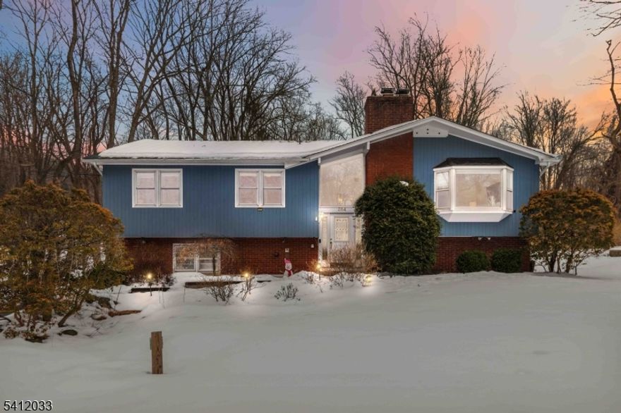 This beautifully maintained home offers exceptional space and comfort from the moment you step inside. The oversized living room is filled with natural light from walls of windows and features high ceilings and gleaming hardwood floors. The large kitchen provides abundant storage, Corian countertops, under-cabinet lighting, and access to a generous deck for warm-weather entertaining. On this level, you'll also find a formal dining room, three oversized bedrooms, including a primary suite with a full bath, plus a full hallway bathroom. The ground level adds valuable flexibility with direct garage access, a laundry room, one additional bedroom, a half bath, and a family room with slider access to the backyard, A long, paved driveway with Belgian block curbs leads to the oversized garage. The home sits on nearly an acre, set back from the road for privacy, with mature trees, a stream with a small footbridge, and landscaped grounds ready to shine again in spring. Natural gas heating, a new boiler, and central air ensure year-round comfort. Recent updates include a new furnace and water heater (fall 2025), a 4-bedroom septic installed in 2022, a whole-house water filter, new bedroom carpeting, and a new dishwasher, washer, and dryer. All located in the highly sought-after Randolph school district, close to parks, trails, and local amenities.