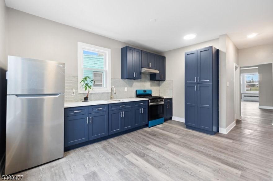 Welcome to this beautifully updated 3 bedroom, 1 bath apartment offering modern finishes and plenty of natural light throughout. The unit features an open and airy layout with brand new flooring and fresh neutral paint that complements any decor style. Enjoy cooking in the stunning eat-in kitchen, complete with sleek navy cabinetry, stainless steel appliances, quartz countertops, and elegant tile backsplash. The adjoining living and dining areas provide the perfect flow for entertaining and everyday living. Each bedroom offers ample space and comfort, while the fully updated bathroom blends style and functionality. Additional highlights include large windows for abundant sunlight, radiator heat, and access to a shared outdoor area. Conveniently located on a quiet residential street in the desirable Weequahic section, close to schools, parks, shopping, and major highways! Don't miss the opportunity to make this modern apartment your new home!