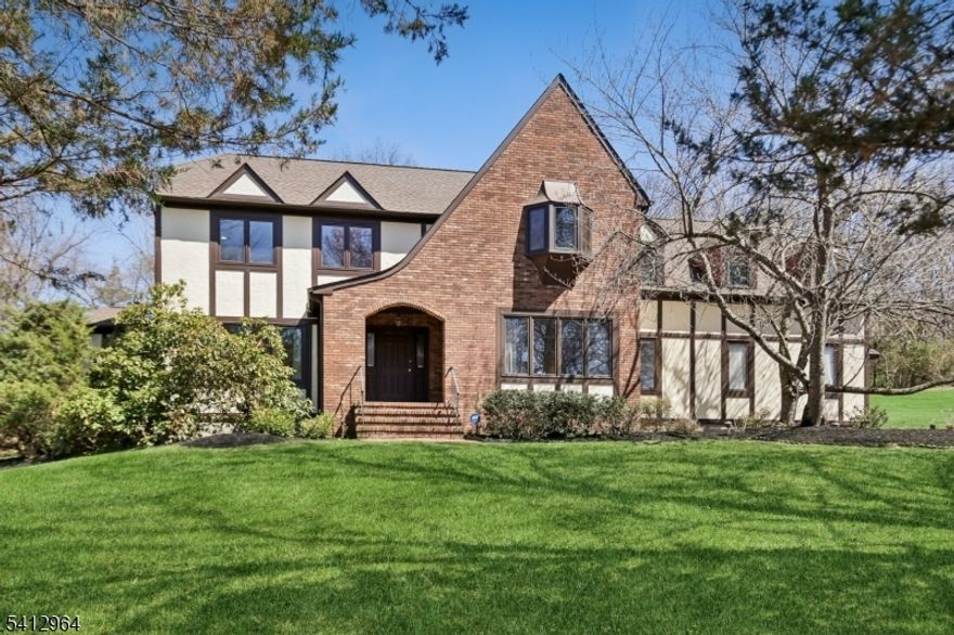 Tudor Colonial   Bernards Twp Basking Ridge   5 BR   3 full BA   3,720 sf   0.88 acres   Roof 2021   Sunroom   3-car garage   1,879 sf unfinished basement....Set on 0.88 acres in Basking Ridge, 34 Knollcroft Rd offers 11 rooms, 5 bedrooms and 3 full baths with a classic layout for everyday living. Close proximity to downtown Basking Ridge, parks, shopping and dining. Walking distance to NJ Transit rail and Lakeland bus service. Hardwood floors throughout (except kitchen and second level bonus room). An all-season sunroom connects the kitchen and family room with easy backyard access. The eat-in kitchen features a center island, recessed lighting, a skylight (six skylights in all, some solar powered and programmable), granite counters, and a gas range with stainless refrigerator and dishwasher. A first-floor room with a closet works well as an office or optional guest room, plus a full bath with stall shower and a laundry room with back yard access. Upstairs, the primary suite includes double-door entry, jetted tub, stall shower and four closets including a walk-in, along with additional bedrooms and a large finished room over the garage for flexible use. Enjoy a three-car garage, a newly paved driveway with Belgian block border. The 1,879 sf unfinished basement for storage or future finishing potential, two HVAC units, a 2024 hot water heater, and a 2021 roof. Don't miss this great home in the desirable Bernards Township School district.