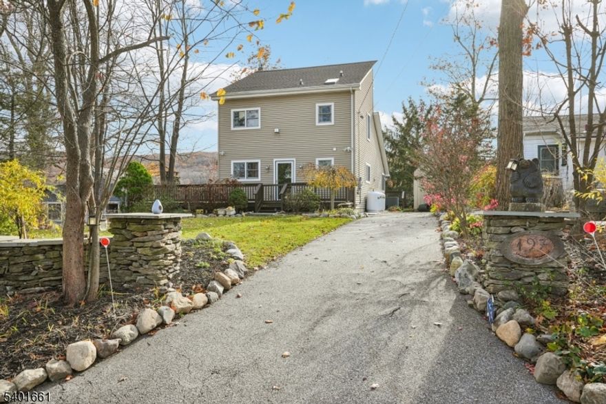 Rare lakefront rental on Upper Greenwood Lake offering breathtaking views, soaring ceilings, and exceptional architectural charm. This 3-bedroom, 2-full-bath home features an open-concept layout designed to maximize natural light and lake views from nearly every room. The main living area showcases dramatic vaulted wood ceilings, hardwood floors, and a striking stone fireplace, creating a warm yet expansive space ideal for both everyday living and entertaining. Walls of windows overlook the lake and open directly to a wraparound deck, perfect for enjoying sunrise coffee or evening sunsets over the water. The eat-in kitchen features high ceilings, abundant cabinetry, and easy access to outdoor dining, flowing seamlessly into the living area. The upper level includes a distinctive catwalk overlooking the living room, connecting the primary bedroom and second bedroom, which share a full bath. The primary bedroom offers a loft area currently used as a home office, along with additional attic storage. A third bedroom and second full bath on the first level provide flexibility for guests or additional living space. The home may be rented furnished for a turnkey lakefront lifestyle, or furnishings can be removed at tenant?s request. Dock usage is available for tenants who wish to enjoy boating and lake activities; association fees apply.