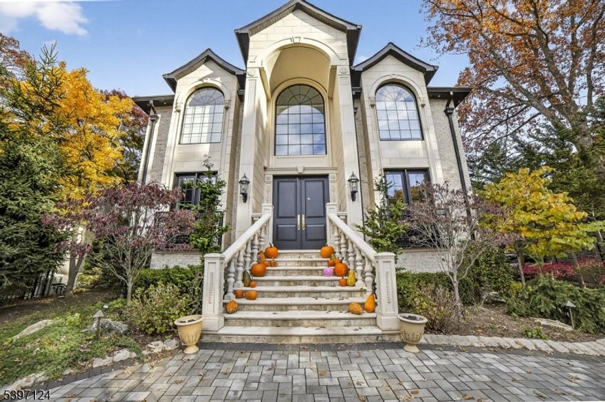 Step into exceptional luxury with this 5-bed, 4.5-bath center-hall Colonial that blends timeless elegance with modern sophistication. The grand two-story foyer features a sweeping curved staircase, soaring ceilings and rich architectural woodwork, including beautifully detailed coffered ceilings. The chef's kitchen is a showstopper, highlighted by a leathered-granite waterfall island, designer cabinetry and premium appliances, ideal for both entertaining and everyday living. The home is fully equipped for the contemporary lifestyle with advanced smart-home automation, high-end security features and multi-zone heating and cooling for total comfort and control. Outside, discover a true private oasis: a pristine gunite pool, spa-style hot tub and lush landscaping create a resort-like setting for recreation and relaxation. Craftsmanship and convenience meet in this exceptional estate.