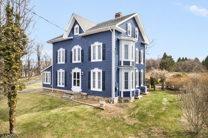 Step into a piece of history in the heart of Knowlton, blending historic bones with a modern soul! Built in the 1800s and once home to the community's only doctor, this historic colonial blends timeless character and craftsmanship with modern updates. The main level features a spacious kitchen, a formal dining room with a fireplace, and an inviting living room with a second fireplace. A brand-new full bathroom and laundry room with pantry on the main floor adds convenience, while the mudroom entrance provides everyday functionality. The sunroom, lined with windows, offers a bright and peaceful retreat overlooking the property. Upstairs, you'll find three generously sized bedrooms and a second full bathroom, all accessed by two separate staircases on the first floor. An additional staircase leads to a third-level unfinished attic, already framed and ready for expansion for future bedrooms, office space or a creative studio. With newer windows, central A/C installed, new siding, fresh paint, and refreshed with hardwood flooring throughout, this home feels beautifully renewed while preserving its historic charm. Set on nearly an acre, the property features a wraparound driveway, patio, fire pit area, garden area, and a large storage shed creating a functional outdoor lifestyle. Located just minutes from Route 80 for easy commuting, yet nestled in the peaceful countryside of rural Warren County, this remarkable home offers history and beauty all in one extraordinary setting.