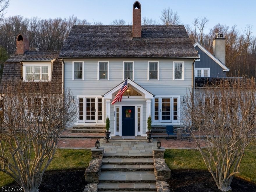 Rows of flowering pear trees and thousands of bulbs herald the arrival of spring at this manicured property exuding New England vibes right at the edge of Hopewell in Montgomery Township. Inspired by the historic designs, then expanded with a "barn  addition, the house showcases artistic craftsmanship. Local firm Material Design Build has put the latest unique architectural details in their renovation of the entire first floor with a new kitchen that will inspire even the most reluctant chef: 3 ovens, 3 sinks, 2 dishwashers, an induction cooktop, Wolf range, and Side-by-side Sub-Zeros. An alcove bar serves the dining room, where rustic wood dresses the ceiling and wine storage lines the walls. The fireplace in the step-down family room is especially eye-catching, trimmed in blue to match wraparound built-ins and complement the coffered ceiling hiding a state-of-the-art Sonos system. Loads of storage can be found near the 3-car epoxy-floored garage with EV charging station. All bedrooms, as well as a top floor bonus room, have dedicated baths. The impressive main suite is the most luxurious with sky-high windows, direct access to the dressing area and deck with a majestic view. Yet another full bath serves the lower level with french doors to a stone patio and perhaps a future pool. Even with money-saving solar panels and a Walpole picket fenced bocce court, there's still plenty of space for one on the nearly 4-acre lot. Owner is a licensed NJ real estate broker.