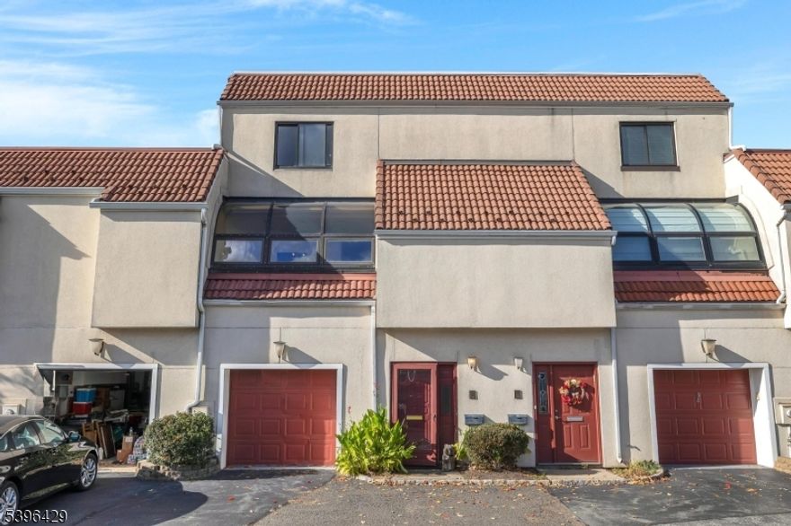 Welcome to Eagle Ridge, a sought-after gated community offering 24-hour security and resort-style amenities. This spacious multi-level townhouse features 2 bedrooms, 2.5 baths, and a 1-car garage. Freshly painted and filled with natural light, the home showcases distinctive Mid-Century-inspired design with clean contemporary lines, built-ins, large windows, and parquet wood floors throughout. The bright galley kitchen stands out with bold red cabinetry, stainless-steel appliances, and sleek finishes, opening to a sun-filled dining area. Both bedrooms are generously sized with ample closet space and access to full baths; the primary suite includes a fireplace and walk-in closet. While move-in ready, the home offers opportunity for personal updates or remodeling to suit your style. Enjoy indoor/outdoor pools, tennis, fitness center, clubhouse, and proximity to shopping, dining, and NYC transportation.