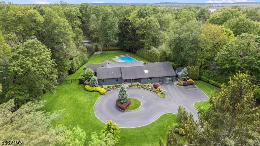 4 Creighton Drive is a mid-century modern showpiece in Livingston's prestigious multi-million dollar Coventry neighborhood. Set back on a beautifully landscaped .9-acre lot with a grand circular driveway, this California-inspired home seamlessly blends high design with everyday comfort. Clean lines, oversized windows, and wide-plank hardwood floors anchor the open-concept layout, while curated finishes, designer light fixtures, and smart home upgrades elevate every detail. The custom kitchen features a center island, Sub-Zero refrigeration, Wolf range, Viking and Bosch appliances, dual built-in ovens, and sleek custom cabinetry. It flows into the dining area and living room, and just beyond, a vaulted family room with a skylight and oversized sliders opens to the backyard for effortless indoor/outdoor living. The primary suite is bathed in natural light and styled with tailored window treatments and tray ceilings, exuding a boutique-hotel feel. A walk-in closet provides generous storage, while tranquil views of the pool and backyard complete the experience with a glass door opening to the covered patio. The finished lower level includes a recreation room, 5th bedroom, full bath, and an additional home office/flex space. Outside, the private backyard is designed for both relaxation and entertaining, with a year round covered travertine patio, a heated in-ground pool, and an expansive lawn. Every detail has been carefully curated?this home is move-in ready!