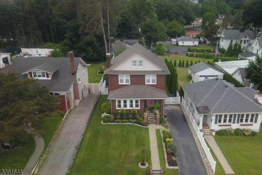 Welcome home to this classic country charmer in Boonton's desirable Park Section! This brick beauty greets you with a welcoming front porch and a craftsman-style door that sets the tone for the character within. Inside, the formal living room features a cozy wood-burning fireplace and double French doors that open to a sunlit enclosed porch perfect for relaxing with morning coffee or evening reads. The gracious dining room is ideal for hosting special gatherings, while the updated kitchen boasts granite counters and stainless steel appliances. A convenient mudroom with direct yard access and a powder room complete the first level. Upstairs, you'll find three comfortable bedrooms plus the flexibility to create a fourth, along with an updated full bath featuring in-home laundry. Hardwood floors flow throughout, adding warmth and charm. The full walk-up attic provides generous storage space, while the finished basement offers even more living options with a full bath and sliding doors leading to two patios. Outside, enjoy a good-sized fenced yard with an above-ground pool great for summer fun. Located just minutes from Boonton's thriving town center, you'll love the variety of shops, cafes, and small-town charm this community has to offer. Commuters will appreciate easy access to major highways and NYC transportation. Don't miss the chance to make this wonderful home yours