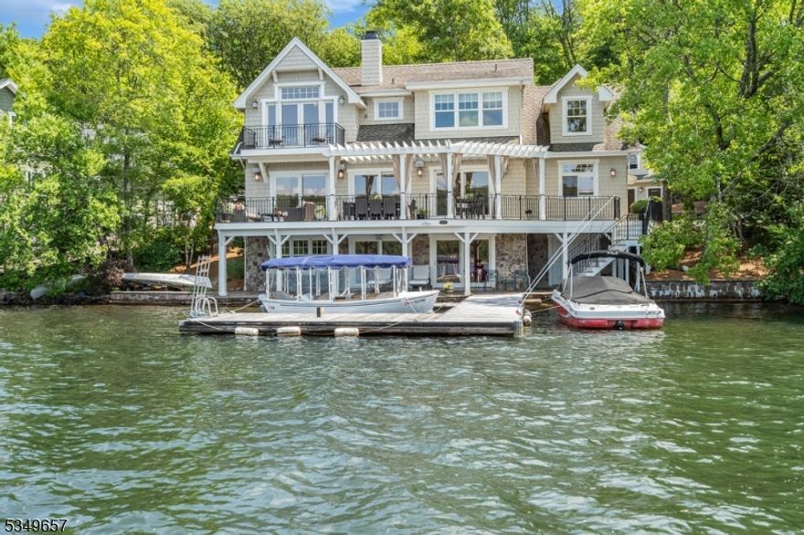 This 2010 custom-built home offers over 5000 sq ft of exquisite living space across three floors. As you approach the property, you are greeted by two paver block driveways, accommodating up to eight cars, leading to an oversized 3+ car heated and air-conditioned garage. Above the garage, discover an additional 900+ sq ft of finished space, perfect for a studio, office or rec room.Inside the the home, the first floor features a wall of sliding glass doors to a spacious deck overlooking the lake, radiant heated hardwood flooring, Norwood thermopane windows, and custom built-ins throughout. The kitchen equipped with a Sub-Zero refrigerator, two dishwashers, two U-Line refrigerator drawers, a Viking cooktop, and Thermador double wall ovens is a chefs dream. The great room, with a full wet bar with 2 beverage refrigerators, a stunning stone gas fireplace, surround sound system, full house sonos and smart TV create a cozy yet sophisticated ambiance. For added convenience, there is a first floor ensuite office/bonus room with a built-in Murphy bed, ideal for guests or a private workspace.The bedroom level has three oversized bedrooms.The primary suite boasts a cathedral ceiling, a built-in beverage refrigerator, a gas fireplace, and a luxurious ensuite bathroom. Additionally, the primary suite features its own private deck, providing a tranquil retreat with panoramic lake views.The walkout lake level features a custom summer kitchen with  a sauna and a wine room.