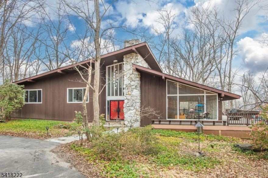 Your one-of-a-kind midcentury modern masterpiece awaits on 3 acres in Hillsborough. Step into architectural design and an open floor plan as you head into your serene living room with luxurious fireplace framed by a unique Feldspar quartz rock formation. A wall of sliding doors allows natural light to drench the space as you open into the formal dining room. Don't miss the view over your back deck and into your yard before heading into your custom kitchen with Miele stainless steel appliances and built-in coffee machine, center island, and style for days. You find a cozy family room with fireplace, built-ins, a water feature, and unique lighting flanking the kitchen, connecting each space with feng shui intention. Head up one level to find your primary bedroom with an en suite bath, as well as two other large bedrooms with a second full hall bath. Your bathrooms are truly works of art. A top-level open-air loft with a secret room through a bookcase add even more family space. Head down to the ground level to find a sitting area, screened porch, laundry room, 2-car garage, and your third unique full bath before you find even more space with a huge basement rec room with a third fireplace. Your long private driveway stops at a circular drive in front and continues around to your garage in the back. A wraparound deck surrounds the house and blends into the nature setting. This is truly a home that never gets old coming home to.